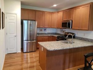 Heritage Greene kitchen with wood cabinets and variety of appliances in Sellersville, PA apartment