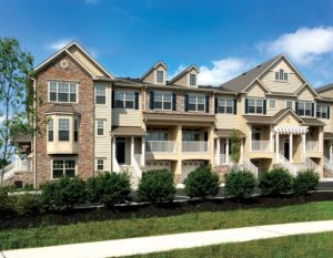 Exterior of Heritage Pointe townhomes with front lawn and bushes in Chalfont, PA