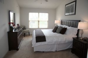 Furnished bedroom with carpeted flooring and large windows in Heritage Pointe apartment in Bucks County, PA