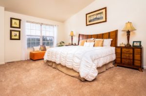 Spacious model bedroom with a large window in Perkaise, PA apartments