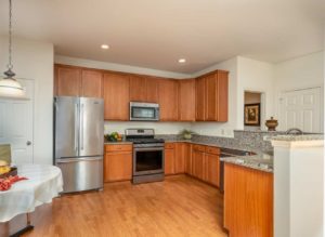 Spacious model kitchen with wood cabinets, stainless steel appliances and white walls in Perkasie, PA